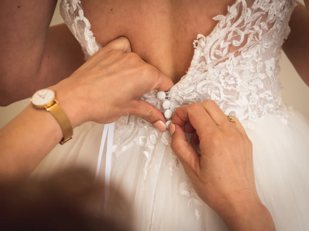 la maman aide la mariée a s' habiller avec sa robe de mariage sur Chaumes en brie